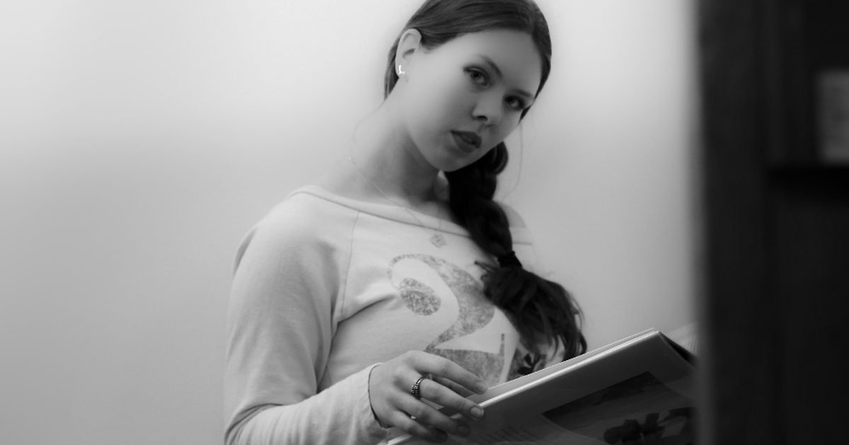 Student writing in a notebook while reviewing study notes