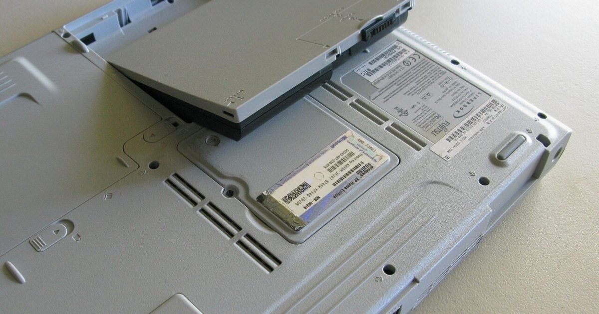 Laptop battery partly removed from the underside of a computer for replacement checks