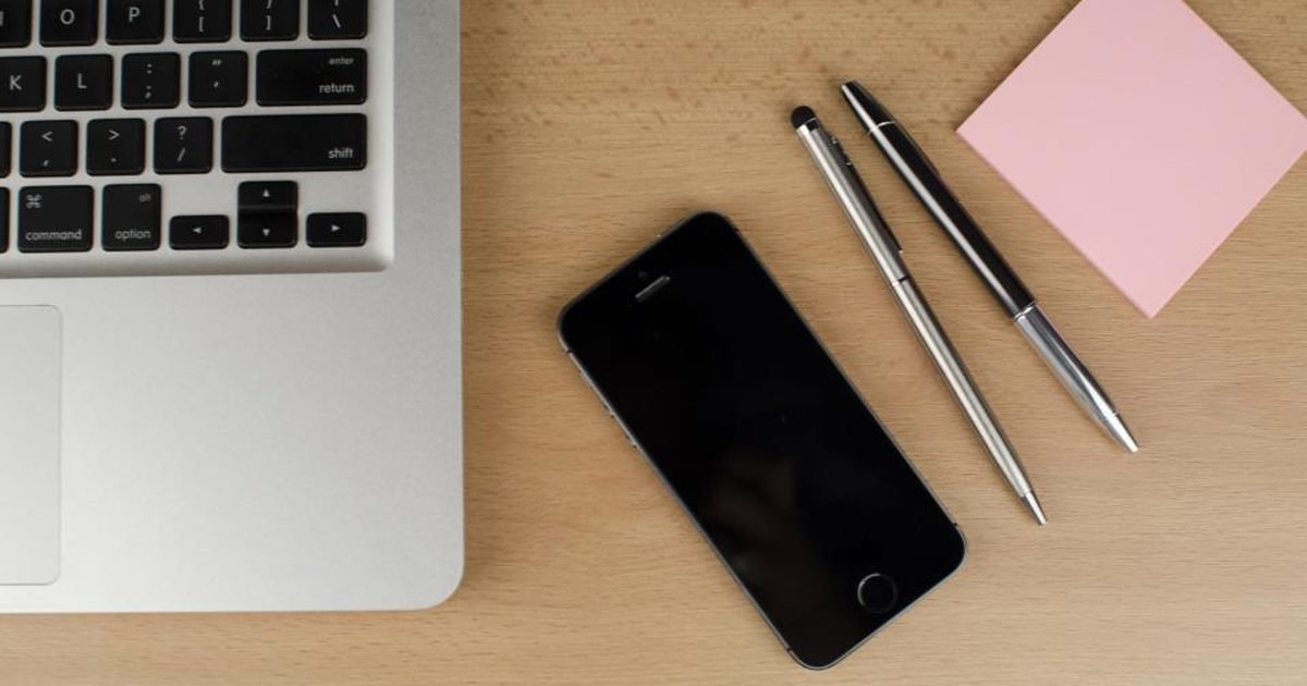Laptop, phone and stationery on a desk for checking AI study notes