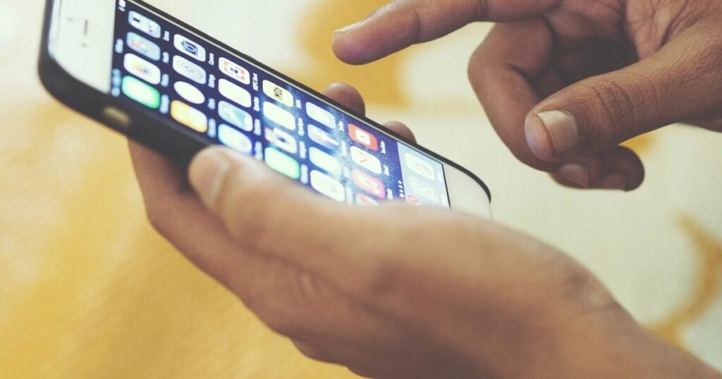 A hand using a smartphone while reviewing Android assistant privacy settings