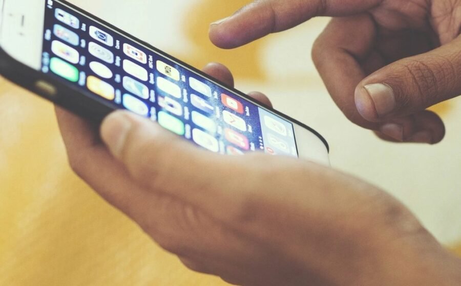 A hand using a smartphone while reviewing Android assistant privacy settings