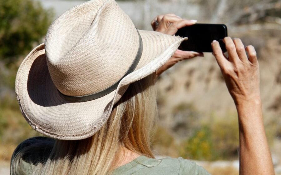 Person using a smartphone outdoors, representing everyday phone storage cleanup