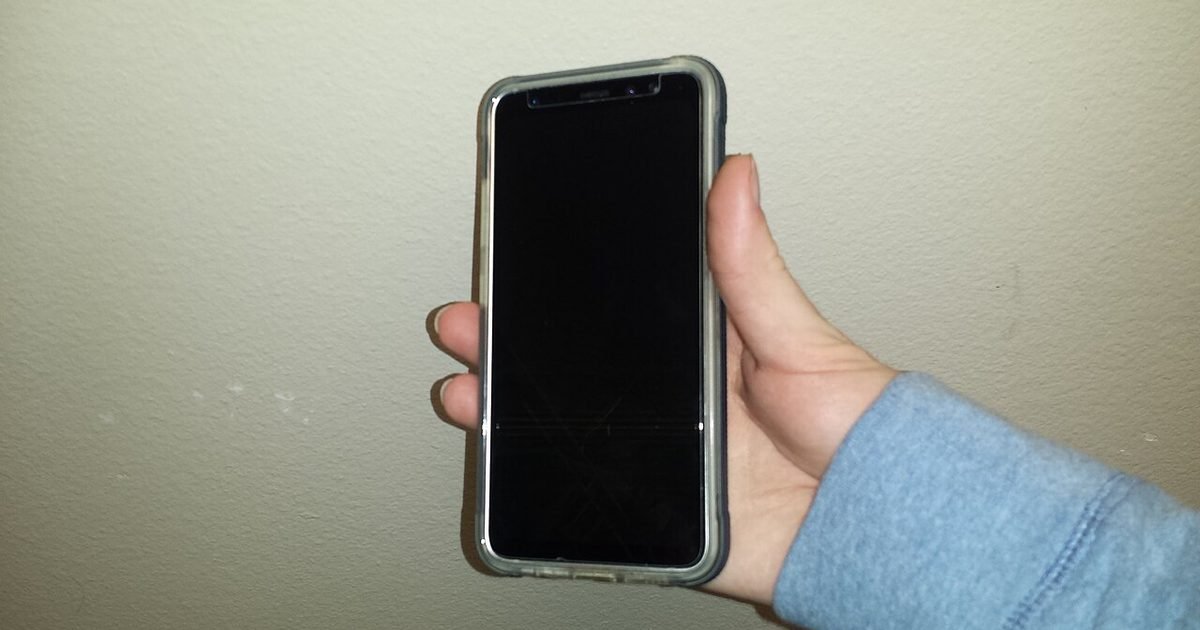 Phone held with a dark screen protector, showing the viewing-angle trade-off.