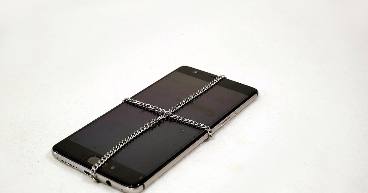 A smartphone wrapped with a chain to represent locking down private phone data