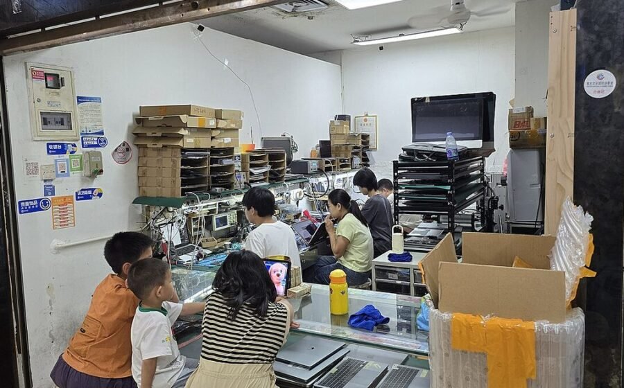 Technicians working in a laptop repair shop, used as the featured image for a laptop battery replacement guide.