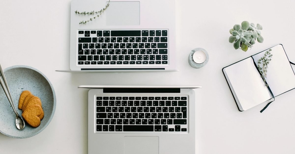 Two laptops on a desk, illustrating battery symptoms and everyday runtime checks.