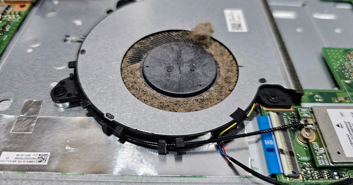 Dusty laptop cooling fan inside an opened laptop