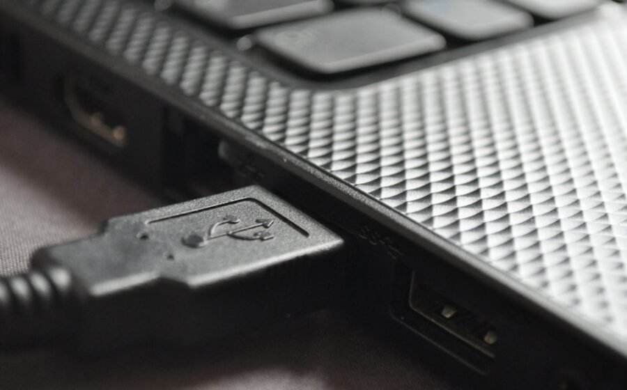 Close-up USB cable plugged into a laptop port for a USB-C hub versus dock buying guide